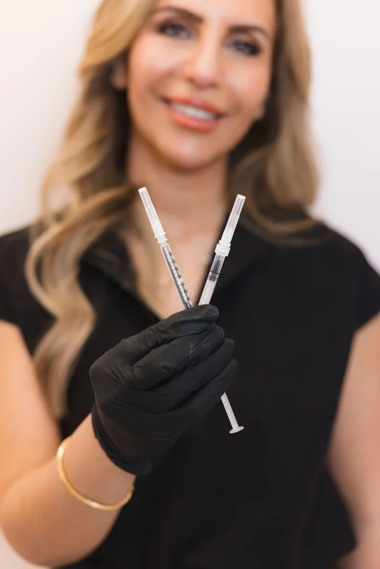 A medical aesthetic practitioner holding filler injectables